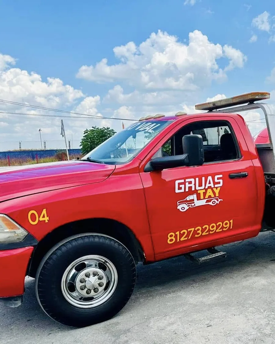 Unidad 04 de Grúas TAY con el rótulo y el número 812 732 9291 en la puerta
